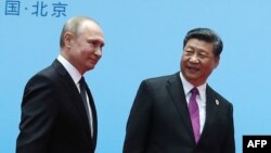 China's President Xi Jinping, right, and Russia's President Vladimir Putin smile during the welcoming ceremony on the final day of the Belt and Road Forum in Beijing, April 27, 2019.