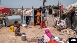 FILE - A mother of 8 children exits part of her house as her children stay around in an informal settlement of internally displaced people in the outskirts of the city of Hargeisa, Somaliland, on September 16, 2021.