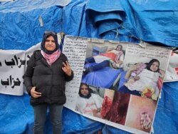 Intesar, 29, poses by photos of herself being treated after she was stabbed during a protest, pictured on Jan. 21, 2020. (Heather Murdock/VOA)