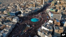 In this aerial photo released by an official website of the office of the Iranian supreme leader, mourners attend a funeral ceremony for Iranian Gen. Qassem Soleimani and his comrades, who were killed in Iraq in a U.S. drone strike on Friday, in Tehran, I