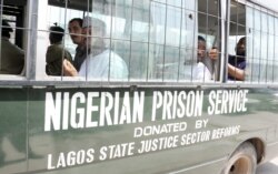 Suspects sit on a bus taking them to prison after a hearing at the Federal High Court in Lagos, March 7, 2011. The prison service is now called the Nigerian Correctional Service.