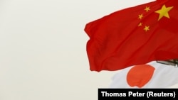 Bendera China dan Jepang berkibar di Beijing, China, 25 Oktober 2018. (Foto: REUTERS/Thomas Peter)