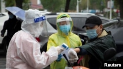 중국 지린성 지린 시내에서 자원봉사자들이 주거지역 출입자 체온을 재고 있다. (자료사진)