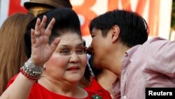 FILE - Philippines Vice-Presidential candidate BongBong Marcos whispers to his mother, former First Lady and Congresswoman Imelda Marcos, before BongBong announced his candidacy in Manila Philippines, October 10, 2015.