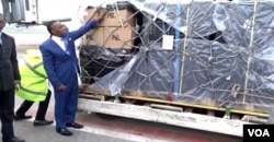 Cameroon's higher education minister, Jacques Fame Ndongo, takes receipt of a shipment of laptops at Yaounde-Nsimalen International Airport, Dec. 25, 2017. (M. Kindzeka/VOA)