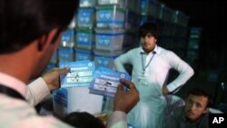 Seorang petugas pemilu Presiden Afghanistan (kiri) menyortir surat suara untuk diaudit di hadapan para pengamat internasional di sebuah TPS di Kabul, Afghanistan, 27 Agustus 2014 (Foto: dok).