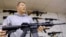 FILE - John Jackson, co-owner of Capitol City Arms Supply, shows off an AR-15 assault rifle for sale, Jan. 16, 2013, at his business in Springfield, Illinois.