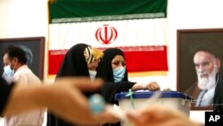 Seorang wanita Iran memberikan suaranya selama pemilihan presiden di sebuah tempat pemungutan suara di dalam konsulat Iran di Karbala, Irak. (Foto: AP)
