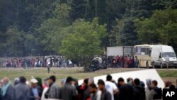 FILE - Migrants and refugees line up for food distribution at the northern Greek border point of Idomeni, Greece, May 2, 2016.