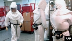 Petugas Departemen Pertahanan, mengenakan baju pelindung, menyortir surat-surat yang masuk di sebuah fasilitas dekat Pentagon di Washington D.C., 2 Oktober 218.