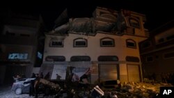 Palestinci utvrđuju štetu nastalu na zgradi na koju je Izrael izveo raketni napad u Gazi, 12. novembra 2019.