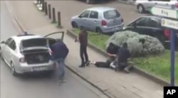 FILE - In this image made from video, police arrest a suspect in the terror attacks in the Anderlecht area of Brussels, April 8, 2016.
