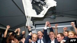 Candidates for the Pe a Corsica nationalist party Jean Guy Talamoni (4L) and Gilles Simeoni (5L) celebrate with party members and supporters after the announcement of the results in the territorial elections in Bastia on the French Mediterranean Island of Corsica, Dec. 10, 2017.