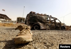 A burnt vehicle belonging to Iraqi security forces is pictured at a checkpoint in Mosul, one day after radical Sunni Muslim insurgents seized control of the city, June 11, 2014.