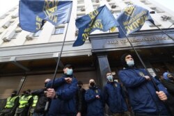 Aktivis gerakan sayap kanan Korps Nasional berkumpul di luar kantor Kejaksaan Agung untuk menuntut hukuman bagi anggota parlemen pro-Rusia dan sekutu Putin Viktor Medvedchuk atas tuduhan pengkhianatan, di Kiev tengah, 25 Maret 2021. (Foto: Sergei SUPINSKY/AFP)