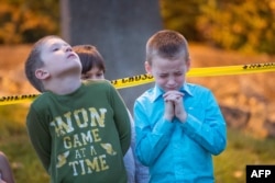 Green Community Church and Lutheran Church Charities of Roseburg, Ore., pray at a memorial in front of Snyder Hall on the campus of Umpqua Community College in Roseburg, Oct. 4, 2015.