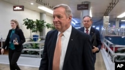 Sen. Dick Durbin, D-Illinois, followed by Sen. Bob Menendez, D-New Jersey, walks in the Capitol in Washington, Jan. 18, 2018.