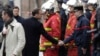 French President Emmanuel Macron (L) shakes hands with a firefighter during a visit in the streets of Paris on Dec. 2, 2018, a day after clashes during a protest of Yellow vests against rising oil prices and living costs. 