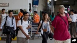 Non-governmental organization staffers arrive in Rangoon from Sittwe, March 27, 2014.