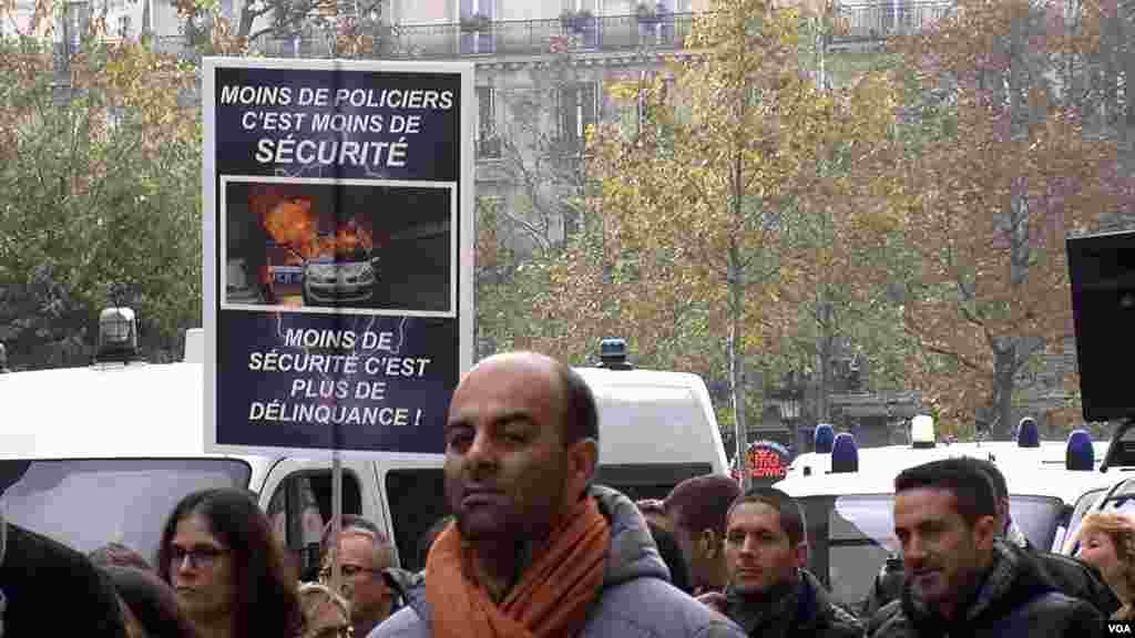 Police protesting in Paris brandish posters like this one, which reads, "Fewer police means less security," Oct. 26, 2016. (L. Bryant/VOA)