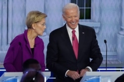 Democratic presidential candidate and Senator Elizabeth Warren talks with former Vice President Joe Biden during a break at the fifth 2020 campaign debate at the Tyler Perry Studios in Atlanta, Nov. 20, 2019.