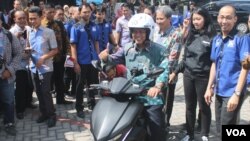 Menristekdikti Mohammad Nasir mencoba motor listrik GESITS karya mahasiswa dan dosen ITS yang siap diproduksi massal (Foto: VOA/Petrus)