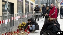 ነዋሪዎቹ ጥቃቱ በተፈፀመበት ቦታ ላይ ሻማ ሲያበሩ ያሳያል፡፡