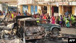 Des résidents regardent les dégâts fait par un attentat, à Mogadiscio, le 14 octobre 2017.