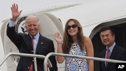 US Vice President Joe Biden, left, waves with his granddaughter Naomi Biden, center, and US Ambassador to China, Gary Locke, right, as they walk out from the Air Force Two upon arrival at the airport in Chengdu, China, August 20, 2011