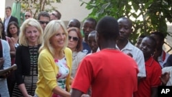 Jill Biden, second left, the wife of American Vice-President Joe Biden, shakes the hand of a former child soldier at a project that benefits from American Aid money in Bukavu, Democratic Republic of Congo, July 5, 2014.