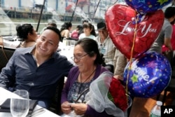 Magdalena Garcia, center, of Morelos, Mexico, sits with her son Candido Macoto, who lives in Brooklyn, as they reunite after 21 years, on the Bateaux New York boat, July 5, 2017 in New York.