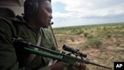 Savannah Elephants: A marksman in a helicopter searches the savannah for wild elephants during an elephant-collaring operation near Kajiado, in southern Kenya, Dec. 3, 2013. 
