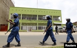 FILE - Riot policemen walk outside the Radio Publique Africaine broadcasting studio in Burundi's capital, Bujumbura, in April 2015.
