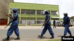 FILE - Riot policemen are seen walking outside the Radio Publique Africaine broadcasting studio in Burundi's capital, Bujumbura, Apr. 26, 2015. 