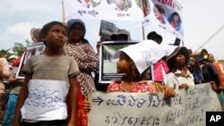 អ្នក​ភូមិ​ឡពាង​ខេត្ត​កំពង់​ឆ្នាំង​កាន់​បដា​ក្នុង​​អំឡុង​ពេល​តវ៉ា​ដាក់​ញត្តិ​នៅ​មុខ​វិមាន​រដ្ឋសភា​ជាតិ​ក្នុង​រាជធានី​ភ្នំពេញ​កាល​ពី​ថ្ងៃ​​ទី​២៥ ខែ​សីហា ឆ្នាំ​២០១៤។