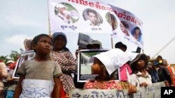 អ្នក​ភូមិ​ឡពាង​ខេត្ត​កំពង់​ឆ្នាំង​កាន់​បដា​ក្នុង​​អំឡុង​ពេល​តវ៉ា​ដាក់​ញត្តិ​នៅ​មុខ​វិមាន​រដ្ឋសភា​ជាតិ​ក្នុង​រាជធានី​ភ្នំពេញ​កាល​ពី​ថ្ងៃ​​ទី​២៥ ខែ​សីហា ឆ្នាំ​២០១៤។