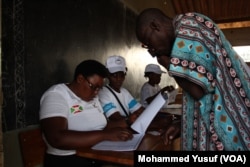 Burundi’s National Election workers check the name of a voter in Cibitoke neighborhood, one of the areas worst hit by weeks of deadly protests in the capital, Bujumbura.