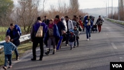 Migrants trudge toward a makeshift refugee camp in the northern Greek border station of Idomeni, where they hope to get permission to move onto other points in Europe, March 4, 2016.