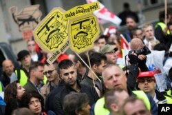 Employees of Amazon protest in front of German publisher Axel Springer's headquarters, where CEO Jeff Bezos was being presented with an award for his "visionary entrepreneurship" in online business and digitalization strategy at The Washington Post, in Berlin, April 24, 2018.