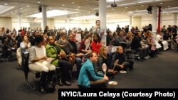 Members of the New York Immigration Coalition watch President Barack Obama's televised speech about his executive order Thursday evening.