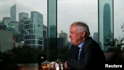 FILE - Former Hong Kong Governor Chris Patten sits in a hotel restaurant overlooking Hong Kong's financial Central district during an interview by Reuters in Hong Kong, March 15, 2012. 