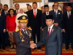 Kepala Kepolisian Republik Indonesia Baru Jenderal Idham Aziz (kiri), berjabat tangan dengan Presiden Indonesia Idham Aziz, seusai upacara pelantikan di Istana Negara, Jakarta, Jumat, 1 November 2019. (Foto AP / Achmad Ibrahim)