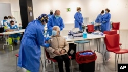 Seorang pria menjalani tes swab Covid-19 di kawasan permukiman para pekerja di distrik Vallecas, Madrid, Spanyol, Jumat (2/10). 