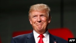 Presiden AS terpilih Donald Trump menyapa para pendukungnya di Macomb Community College pada saat kampanye di Warren, Michigan (31/10). (AFP/Jeff Kowalsky)