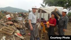 지난해 8월말 북한 적십자 소속 재난대응요원들이 함경북도 회령시 주변 홍수 피해 지역에서 피해 규모를 파악하고 있다. 국제적십자가 당시 공개한 북한 수해 보고서에 들어있는 사진이다.