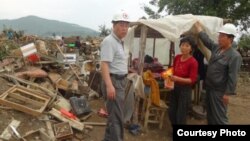 북한 적십자 소속 재난대응요원들이 지난 8월말 함경북도 회령시 주변 홍수 피해 지역에서 피해 규모를 파악하고 있다. 국제적십자가 20일 공개한 북한 수해 보고서에 들어있는 사진이다.