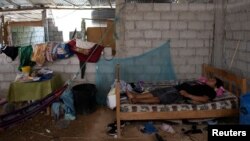 Cristian Jordan, 37, who suffers from dengue fever and is experiencing symptoms consistent with COVID-19, lies on his bed at his home, during the coronavirus disease (COVID-19) outbreak, in Puerto Roma, Ecuador, April 21, 2020. (REUTERS/Santiago Arcos )