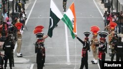 واہگہ بارڈر پر سکیورٹی اہلکار پاکستانی اور بھارتی پرچموں کے ساتھ