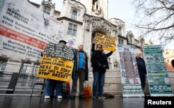 Pro and anti-Brexit protesters stand outside the Supreme Court on the third day of the challenge against a court ruling that Theresa May's government requires parliamentary approval to start the process of leaving the European Union, in Parliament Square,