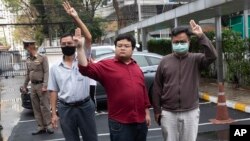 លោក Somyos Prueksakasemsuk (ឆ្វេង) លោក Chiwarak Parit (កណ្តាល) និងលោក Arnon Nampa លើកម្រាមដៃបីតំណាងឲ្យការតស៊ូប្រឆាំង ខណៈពួកគេបានទៅដល់តុលាការព្រហ្មទណ្ឌនៅទីក្រុងបាងកក ប្រទេសថៃ កាលពីថ្ងៃអង្គារ ទី៩ ខែមករា ឆ្នាំ២០២១។